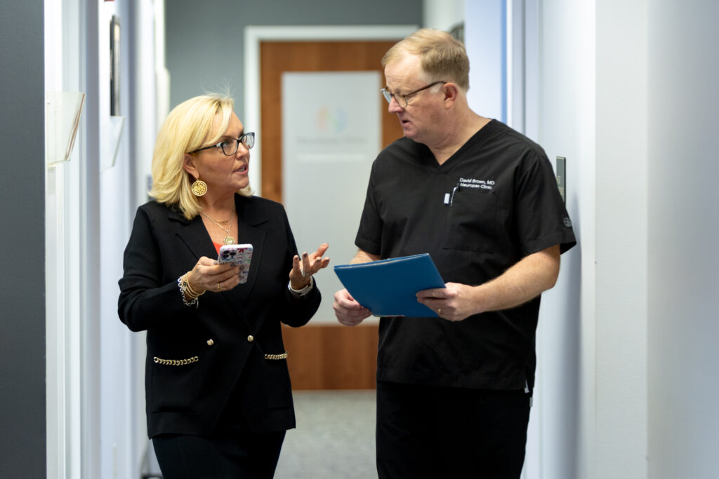 Dr. Brown and an employee having a discussion in the hallway about a patient contact